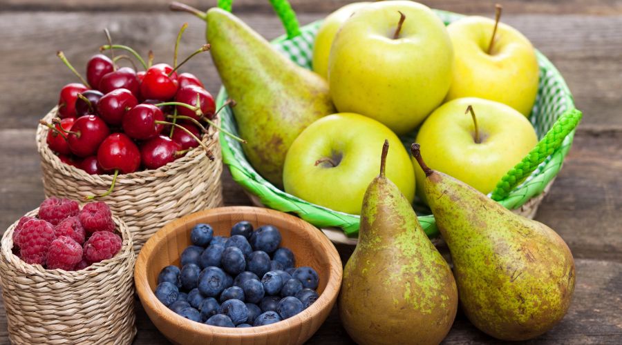 bowls of fruit including apples, pears, cherries, blueberries and raspberries 