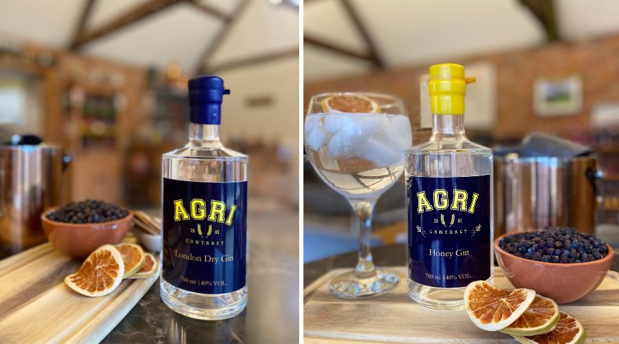 On the left a bottle of Olly Harrison's Agricontract London Dry Gin in a clear bottle with navy and yellow label. On the right, a bottle of Agricontract honey gin