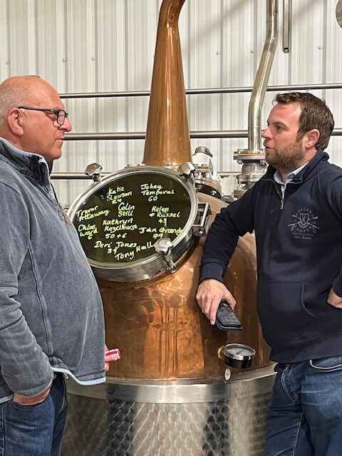 Martin Williams and Olly Harrison standing by a copper still 